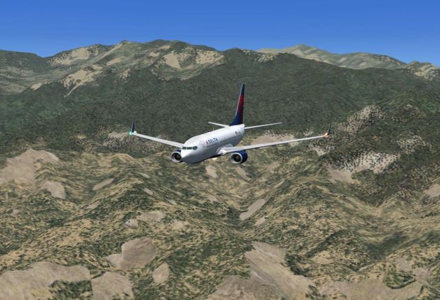 Delta Boeing 737-700  descending over the mountains. From the Microsoft Flight Simulator X gallery.