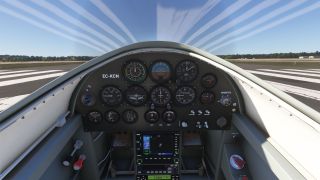 The cockpit features round analog gauges, a central GPS display, and engine controls, with runway threshold markings visible ahead.