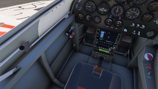 The cockpit contains analog gauges, a color navigation display, a central control stick, rudder pedals, and switches along the right console.