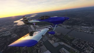 A blue and silver propeller aircraft with striped wings and a checkered tail banks above an urban river under an orange sky.