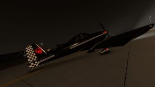 A black single-engine aircraft with white stripes, a checkered tail, and red emblems sits on an airport apron at night.