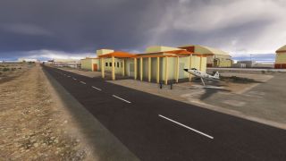 A pedestal-mounted U.S. Air Force jet stands beside a yellow building with orange trim, near a paved road under dark clouds.