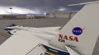 A white and blue NASA jet marked 836 sits on an apron beside hangars under dark clouds.
