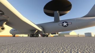 A U.S. Air Force radar aircraft sits on the apron, viewed from beneath its wing with landing gear and radar dome visible.