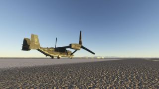 A USAF V-22 Osprey sits on the tarmac with forward-facing rotors, distant hangars, and mountains beneath a clear sky.