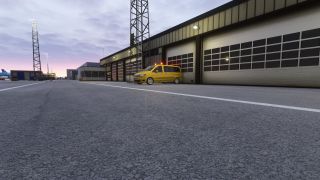A yellow van with illuminated roof beacons sits outside airport garage doors beneath floodlight towers and a pink-gray sky.