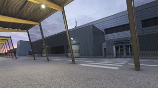 A covered walkway with yellow beams faces an airport terminal’s domestic arrivals entrance, with a zebra crossing leading to glass doors.