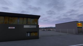 Buildings bearing Jetpak and DHL signs flank a fenced parking area, with snow-covered mountains beneath a cloudy sky.