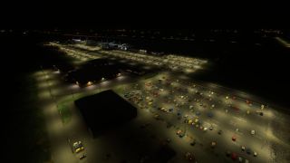 Airport parking lots filled with cars glow under streetlights at night, with terminal buildings and parked aircraft beyond.