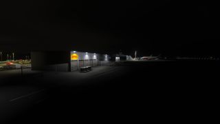 An illuminated DHL cargo building stands beside parked vehicles and cargo carts, with airliners visible on the apron at night.