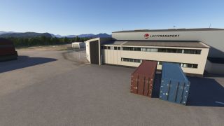 Red and blue shipping containers stand outside a Lufttransport hangar, with trees and mountains visible beyond the paved yard.