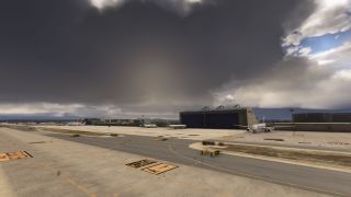 Several airliners sit beside a Globalia hangar, while marked taxiways cross the foreground beneath dark clouds.