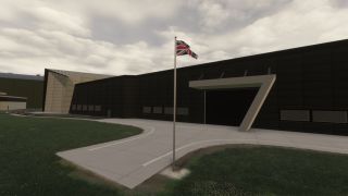A Union Jack flies outside a dark building with an angular entrance canopy, bordered by paved paths and grass under cloudy skies.
