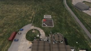 An airfield signal square marked with a white dumbbell sits beside a control tower, parked cars, and a curved-roof hangar.