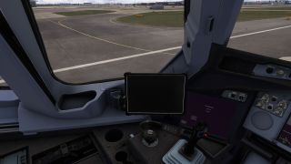 The cockpit side console features a sidestick and blank mounted tablet, with yellow taxiway markings visible through the window.