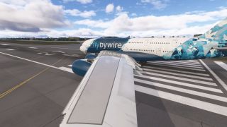 An Airbus A380 in blue geometric livery sits across runway threshold markings, with its wing and two engines dominating the foreground.
