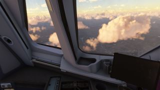 Cockpit side windows overlook sunlit clouds above winding rivers and urban terrain, with a dark tablet mounted beside the window.