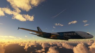A four-engine Airbus A380 in teal-and-white FlyByWire livery flies above scattered golden clouds, with thin contrails crossing the sky overhead.