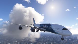 An Airbus A380 in blue and white FlyByWire livery flies above urban terrain with landing gear extended beside towering clouds.
