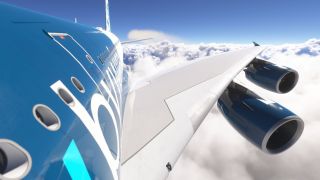 A blue airliner flies above thick clouds, with its fuselage windows, broad white wing, and two blue engine nacelles visible.