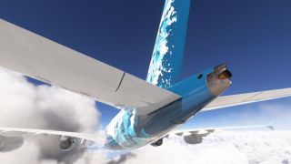 A four-engine airliner flies above clouds, viewed from below and behind with its blue patterned tail and exhaust outlet prominent.