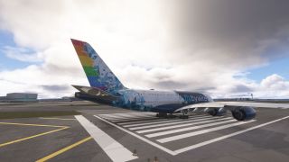An Airbus A380 with a rainbow-striped tail and blue geometric livery sits on runway threshold markings beneath thick clouds.