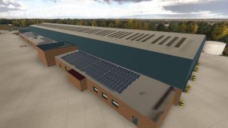 A large blue hangar has rows of roof skylights, adjoining brick offices with solar panels, and a white cylindrical tank beside it.