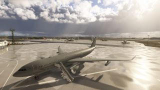 A gray Royal Air Force tanker sits on a wet apron with boarding stairs alongside, while other aircraft park beneath heavy clouds.