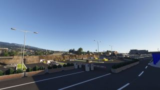 An airport parking area contains cars, yellow taxis, barrier gates, and shrub planters, with covered walkways and hillside buildings beyond.