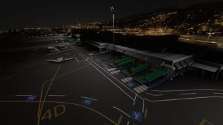 A twin-engine aircraft sits beside an airport terminal with green covered walkways, apron floodlights, and illuminated hills in the night background.