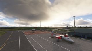 A white twin-engine turboprop with red nacelles and maple leaf markings sits beside an airport terminal under heavy clouds.