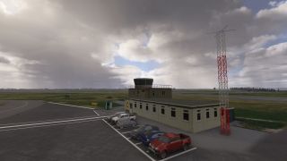 A small airport control building stands beside parked vehicles and a red-and-white antenna mast, with runways beneath heavy clouds.