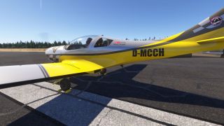 A yellow and white light aircraft marked D-MCCH sits on pavement with wheel chocks and two occupants beneath its clear canopy.