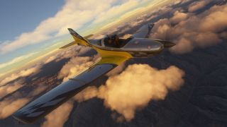 A yellow and silver single-engine aircraft with checkered wingtips flies above mountainous terrain and golden clouds, with two occupants visible.