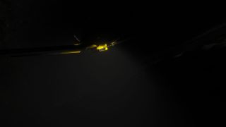 An aircraft flies through a dark, starry sky, with yellow illumination outlining parts of its fuselage and wings.
