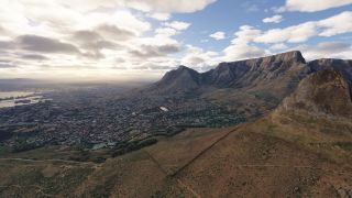 A coastal city and harbor spread beneath a flat-topped mountain ridge, with winding hillside trails and scattered clouds overhead.