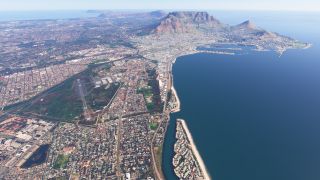 An aerial view shows a coastal runway amid dense urban streets, with harbor docks and a flat-topped mountain across the bay.