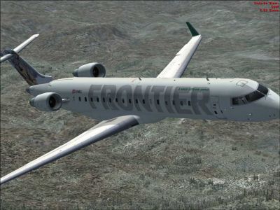 Frontier Bombardier CRJ-700 flying low over mountains.