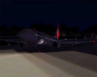 Northwest Airlines Boeing 737-400 taking off from runway at night.