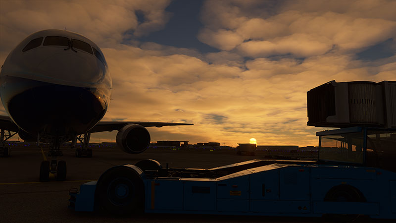 Boeing 787 on ramp preparing for early morning departure with sunrise in the background.