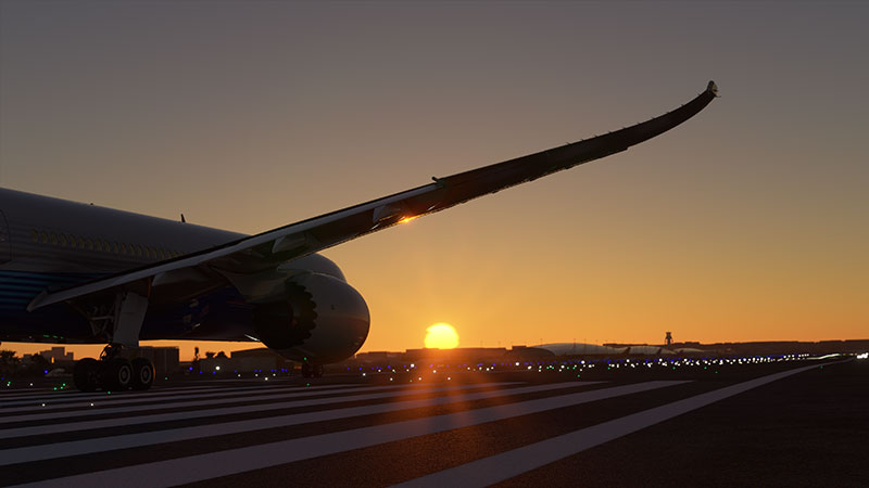 Boeing 787 taking off with sunset in background.
