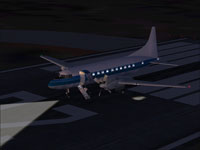Screenshot of blue and white Convair 580 on runway at night.