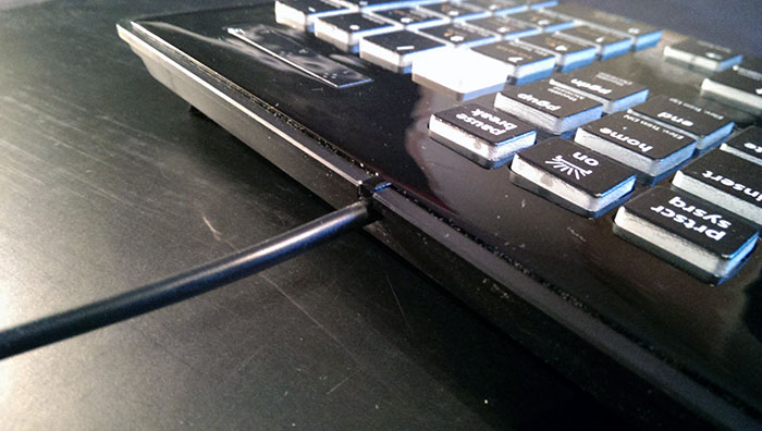Cable output from the keyboard/Glossy black can be a dust magnet.