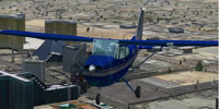 Screenshot of silver and blue Cessna 172SP in flight.