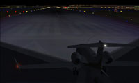 Screenshot of a plane on a dark runway at night.