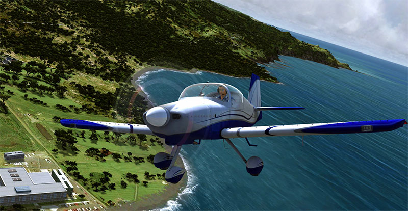 GA aircraft flying over coastline and water.