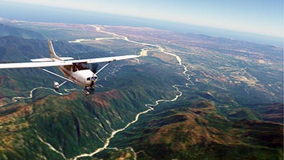 Flying over mountains in X-Plane 12 after installing the Mexico scenery mod.