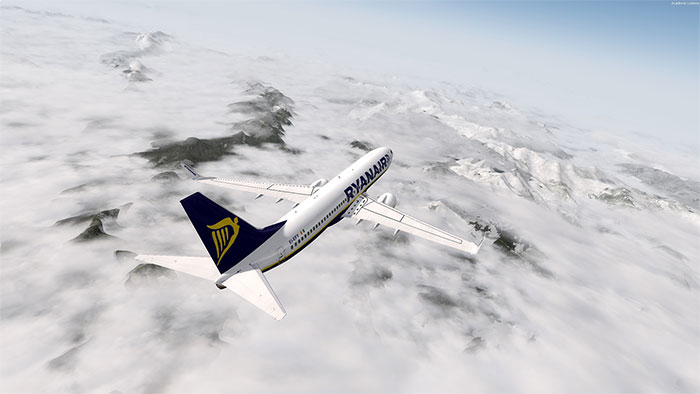 Ryanair 737 flying over mountains with clouds covering them.