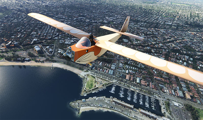 Aurore MB 02 Souricette in flight over a city in MSFS after installing the freeware mod.