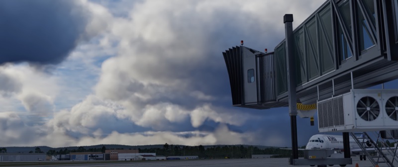 Jetway with massive clouds in distance.